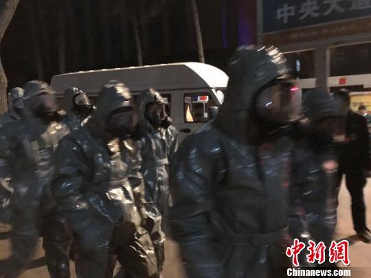 十几名身着防护服的人员头戴面具进入事发地。　胡健 摄